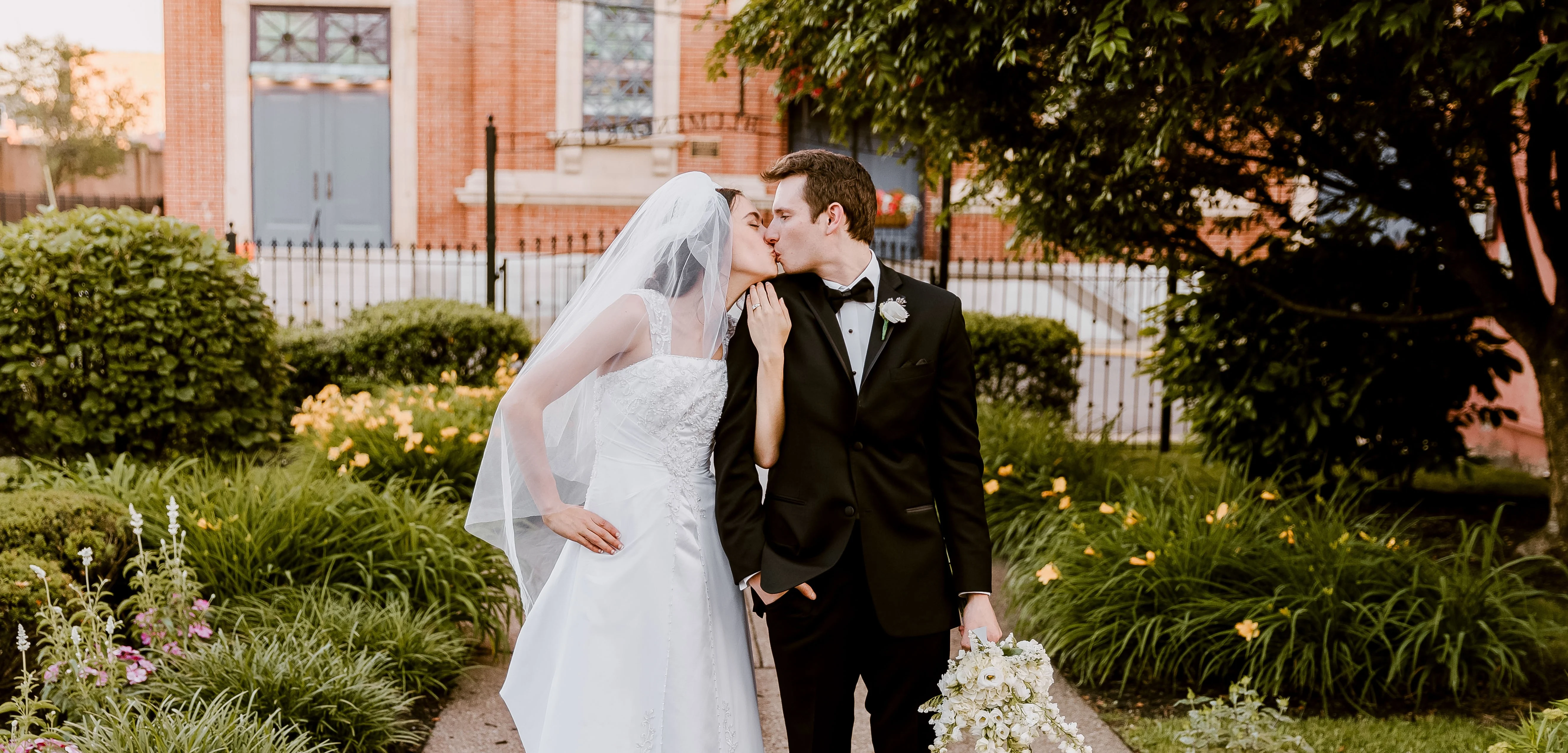 Edited wedding photo of a couple kissing in golden-hour light — warm, true-to-life color grading by EarlEgos